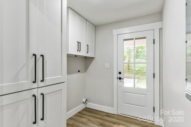 1208 Tarrington Ave, Charlotte, NC 28205 - laundry area featuring cabinet space, electric dryer hookup, and light wood-type flooring