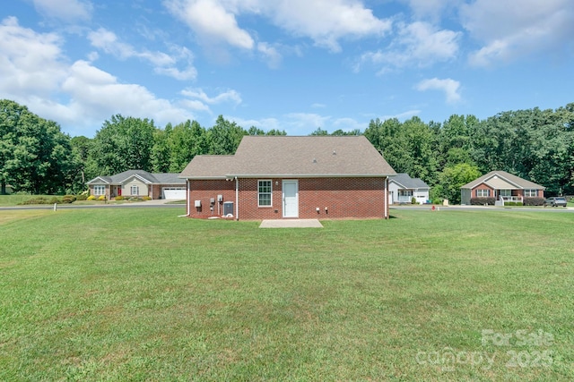 169 Abigail Ln, Locust, NC 28097 - rear view of house featuring a lawn, brick siding, and a garage