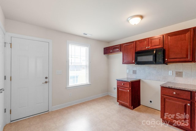 169 Abigail Ln, Locust, NC 28097 - kitchen with backsplash, light stone counters, black microwave, and light floors