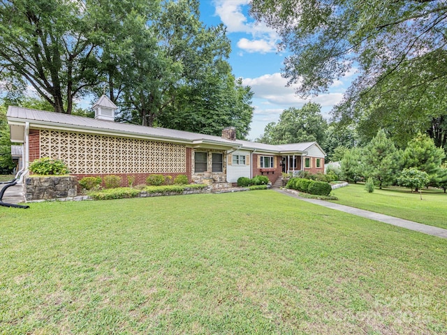 209 11th St, Spencer, NC 28159 - ranch-style house with a front lawn, a chimney, brick siding, and a metal roof