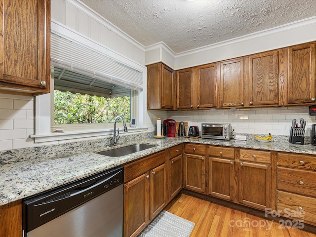 209 11th St, Spencer, NC 28159 - kitchen with stainless steel dishwasher, backsplash, light wood-type flooring, ornamental molding, and brown cabinets