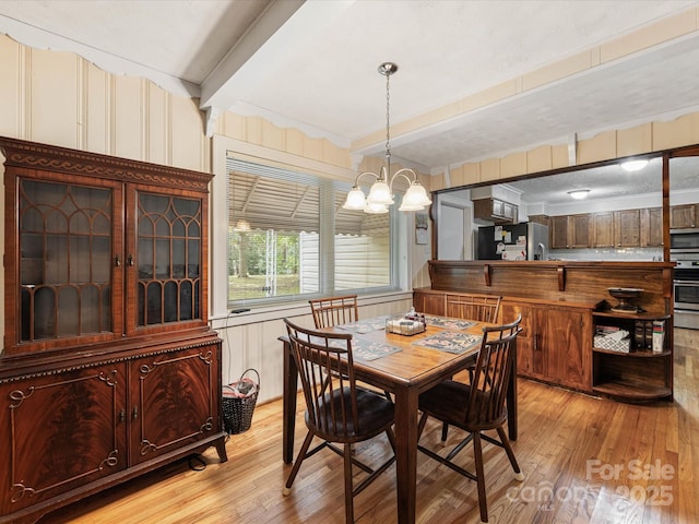 209 11th St, Spencer, NC 28159 - dining room with light wood-type flooring, beam ceiling, and a chandelier