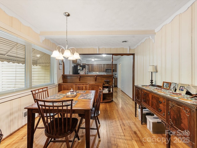 209 11th St, Spencer, NC 28159 - dining space with light wood-style flooring, ornamental molding, beam ceiling, and a chandelier