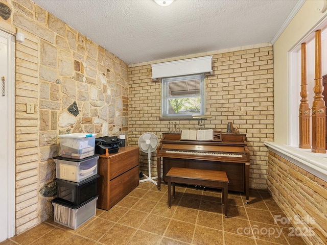 209 11th St, Spencer, NC 28159 - sitting room with a textured ceiling, brick wall, and tile patterned floors