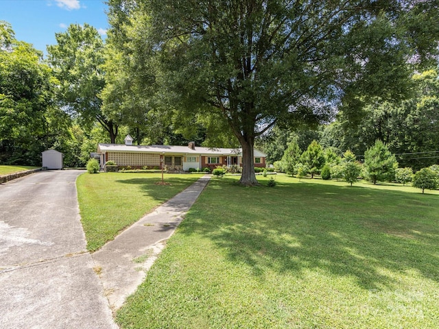 209 11th St, Spencer, NC 28159 - single story home featuring driveway, a front yard, a chimney, and view of wooded area