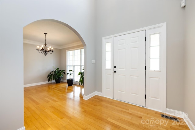1309 Stonewyck Dr, Salisbury, NC 28146 - foyer featuring arched walkways, light wood-style flooring, a chandelier, and ornamental molding