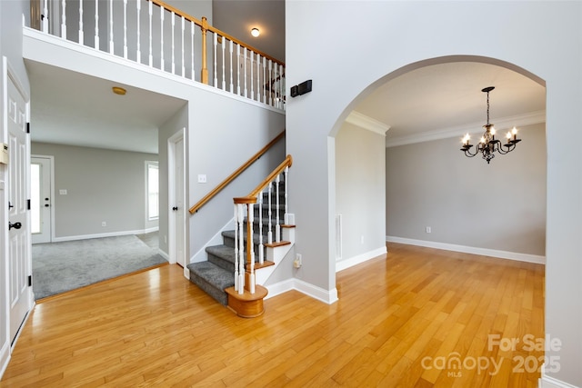 1309 Stonewyck Dr, Salisbury, NC 28146 - entryway featuring arched walkways, light wood-style floors, a chandelier, stairway, and ornamental molding
