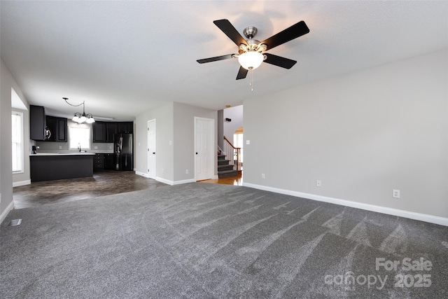 1309 Stonewyck Dr, Salisbury, NC 28146 - unfurnished living room featuring dark carpet, stairway, ceiling fan, and a chandelier