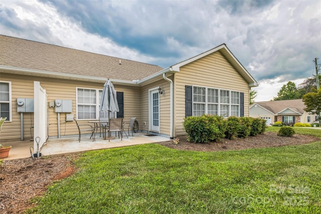 211 Abee St, Morganton, NC 28655 - rear view of house featuring a patio area, a lawn, and roof with shingles