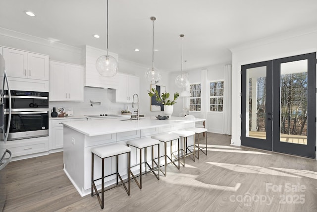 3830 Mill Run, Terrell, NC 28682 - kitchen with crown molding, french doors, a breakfast bar area, light wood-type flooring, and white cabinets