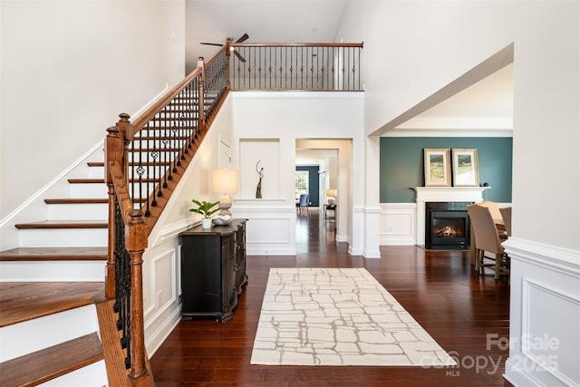 3021 Henshaw Rd, Waxhaw, NC 28173 - staircase with wood finished floors, a glass covered fireplace, a towering ceiling, and ceiling fan