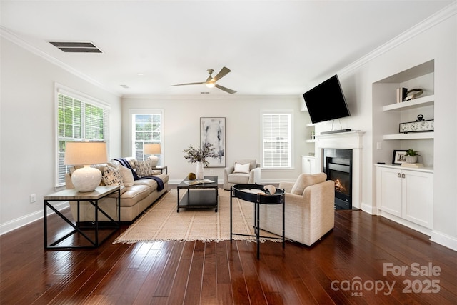 3021 Henshaw Rd, Waxhaw, NC 28173 - living area with a glass covered fireplace, crown molding, dark wood-style flooring, a ceiling fan, and built in shelves