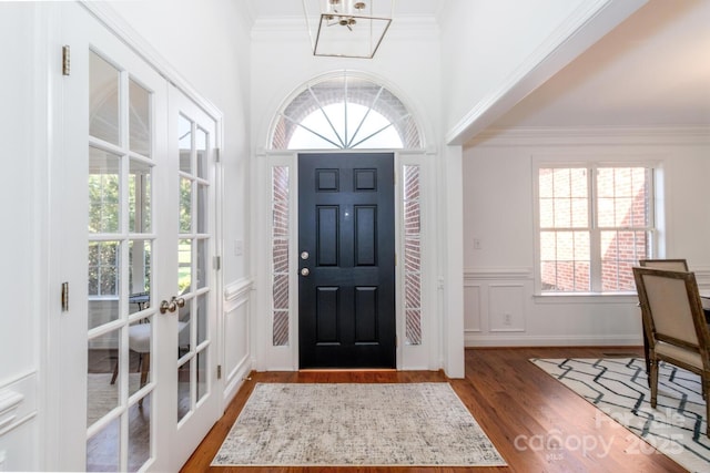 444 Cottonfield Cir, Waxhaw, NC 28173 - entrance foyer featuring wood finished floors, crown molding, a wainscoted wall, french doors, and a decorative wall