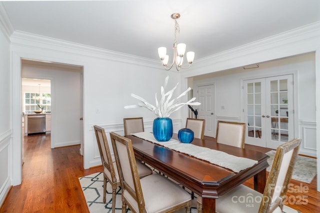 444 Cottonfield Cir, Waxhaw, NC 28173 - dining area with a chandelier, french doors, ornamental molding, a decorative wall, and light wood-type flooring
