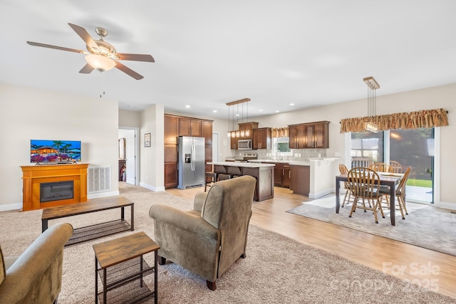 240 Red Cedar Rd, Mooresville, NC 28115 - living room with light wood-type flooring, ceiling fan, a glass covered fireplace, and recessed lighting