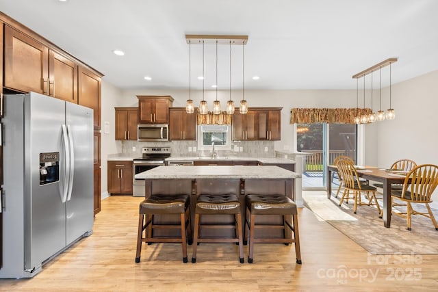 240 Red Cedar Rd, Mooresville, NC 28115 - kitchen with stainless steel appliances, light wood-type flooring, decorative backsplash, a kitchen island, and recessed lighting