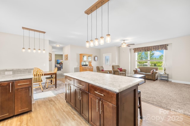240 Red Cedar Rd, Mooresville, NC 28115 - kitchen with open floor plan, light wood-style flooring, hanging light fixtures, and light countertops
