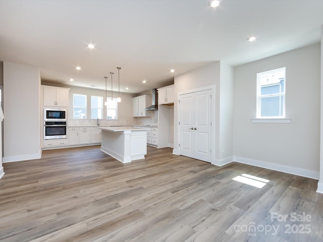 7004 Impulse Ct, Charlotte, NC 28205 - kitchen featuring oven, white cabinetry, tasteful backsplash, a kitchen island, and light countertops