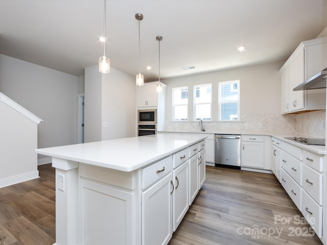 7004 Impulse Ct, Charlotte, NC 28205 - kitchen with decorative backsplash, a center island, black appliances, white cabinetry, and recessed lighting