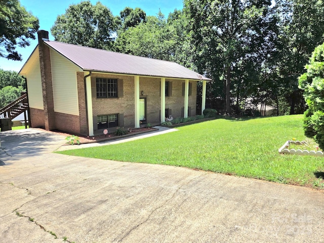 717 2nd St SW, Conover, NC 28613 - raised ranch featuring brick siding, a chimney, a metal roof, a front yard, and concrete driveway