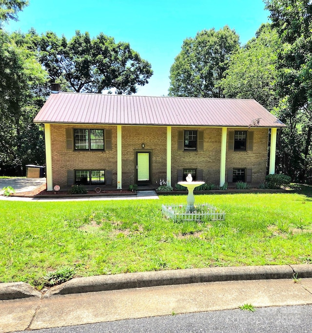 717 2nd St SW, Conover, NC 28613 - raised ranch featuring a metal roof, a porch, a front yard, and brick siding