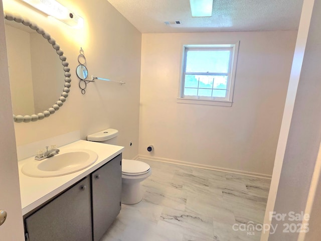 717 2nd St SW, Conover, NC 28613 - bathroom with marble look tiles, vanity, and a textured ceiling