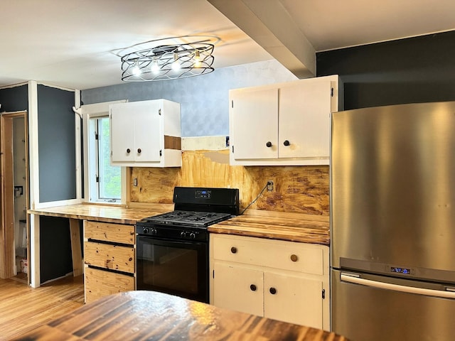 491 W Main St, Waldoboro, ME 04572 - kitchen with freestanding refrigerator, black gas range oven, light wood-style flooring, butcher block counters, and white cabinets