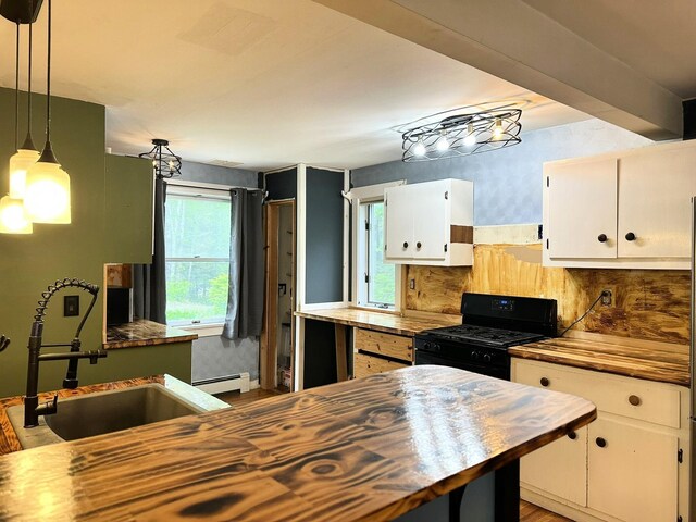 491 W Main St, Waldoboro, ME 04572 - kitchen featuring butcher block countertops, black gas range, a sink, a baseboard heating unit, and white cabinetry