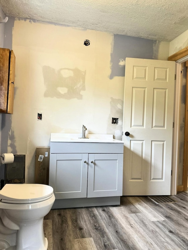 491 W Main St, Waldoboro, ME 04572 - bathroom with vanity, toilet, wood finished floors, and a textured ceiling