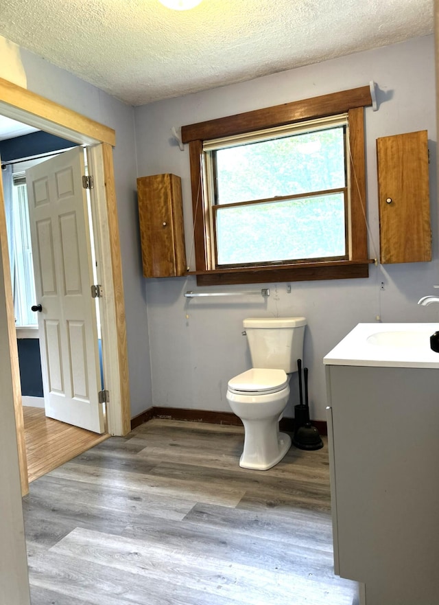 491 W Main St, Waldoboro, ME 04572 - bathroom featuring vanity, wood finished floors, toilet, a textured ceiling, and baseboards