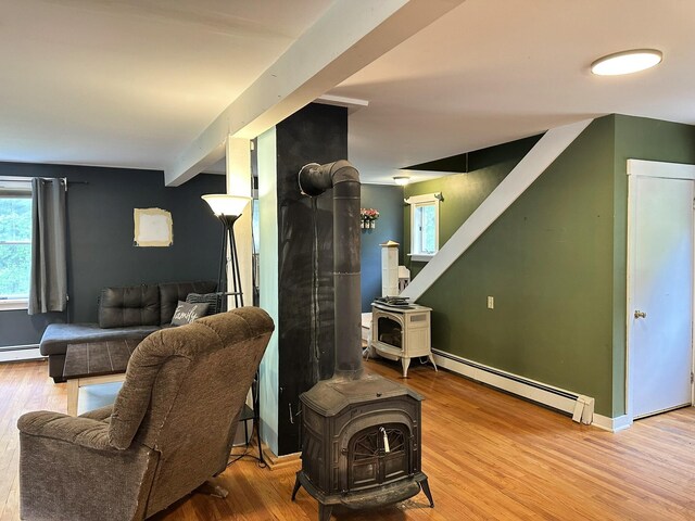 491 W Main St, Waldoboro, ME 04572 - living area featuring a wood stove, wood finished floors, and a baseboard heating unit