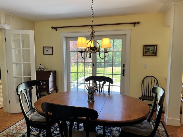 dining space featuring hardwood / wood-style flooring, a wealth of natural light, and a chandelier