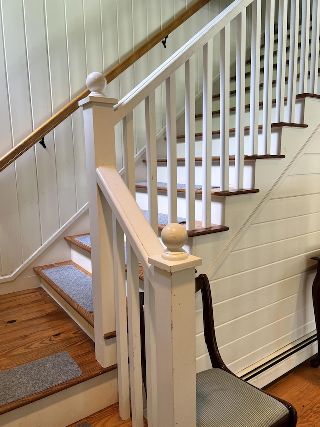 staircase with hardwood / wood-style flooring and a baseboard radiator