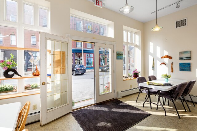 interior space with french doors, track lighting, a baseboard heating unit, and light tile flooring