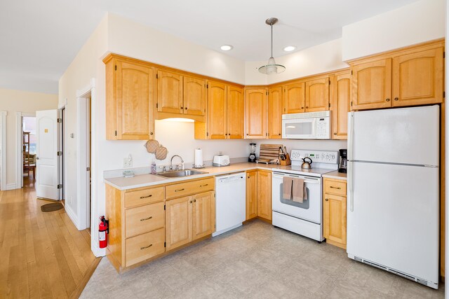 kitchen with hanging light fixtures, white appliances, sink, and light tile floors