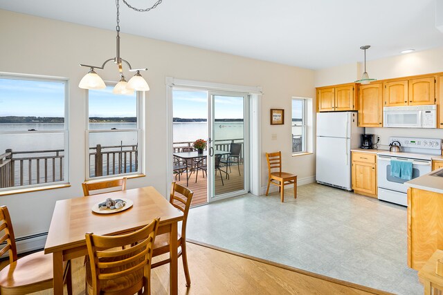 tiled dining area with a water view and a chandelier