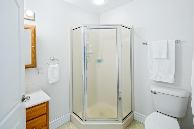 bathroom with an enclosed shower, vanity, tile flooring, and toilet