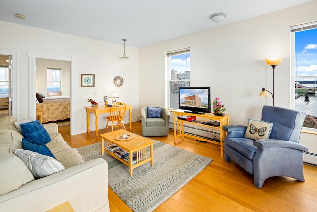 living room featuring baseboard heating and light hardwood / wood-style floors