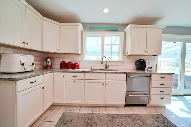 428 Main St, Orono, ME 04473 - kitchen featuring plenty of natural light, a sink, decorative backsplash, white cabinetry, and recessed lighting