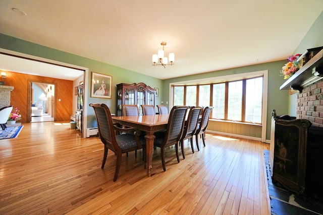 428 Main St, Orono, ME 04473 - dining space featuring a fireplace, a chandelier, light wood-style floors, and a baseboard heating unit