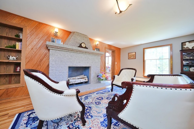 428 Main St, Orono, ME 04473 - living area with wood walls, wood finished floors, a brick fireplace, and baseboard heating