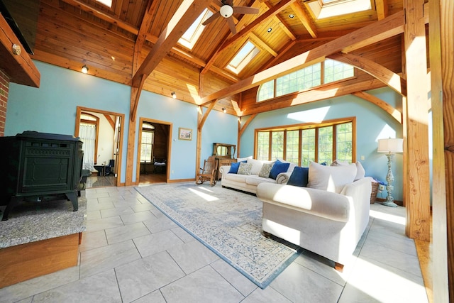428 Main St, Orono, ME 04473 - living room featuring a skylight, high vaulted ceiling, wooden ceiling with exposed beams, plenty of natural light, and a wood stove