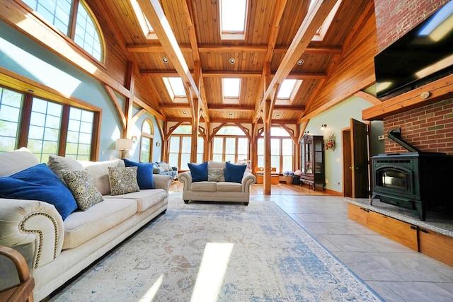 428 Main St, Orono, ME 04473 - living room featuring a skylight, wood ceiling with exposed beams, a wood stove, plenty of natural light, and high vaulted ceiling