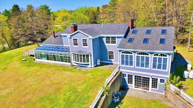428 Main St, Orono, ME 04473 - back of property featuring a chimney, roof with shingles, a view of trees, a sunroom, and a patio area