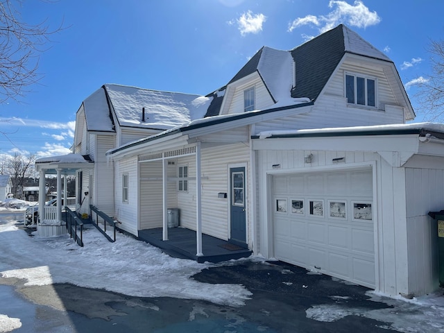 view of snow covered exterior featuring a garage