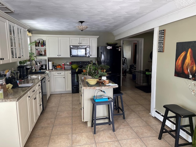 kitchen featuring white cabinets, a breakfast bar area, light tile floors, and black appliances