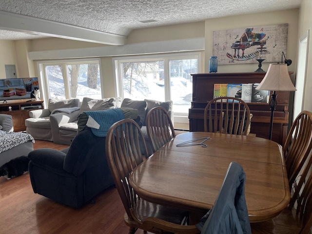 dining room with dark hardwood / wood-style floors and a textured ceiling