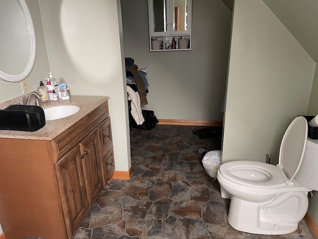 bathroom with toilet, tile floors, and vanity