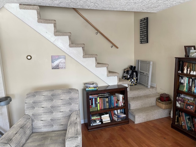 stairway featuring a textured ceiling and dark hardwood / wood-style flooring