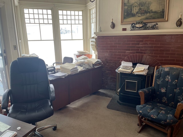 carpeted office space featuring a healthy amount of sunlight and a wood stove